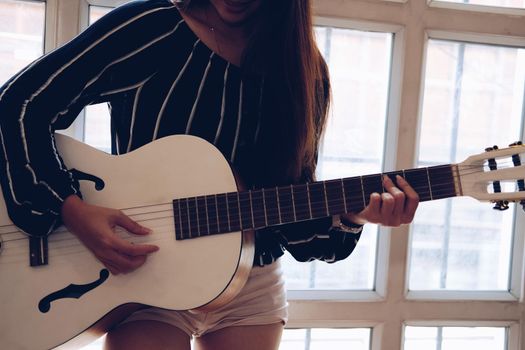 woman playing guitar at home.  leisure lifestyle concept