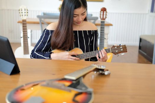 woman playing guitar at home.  leisure lifestyle concept