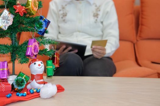 woman holding credit card & tablet for online shopping.  female buyer buying christmas gift on internet. new year holiday merry xmas celebration