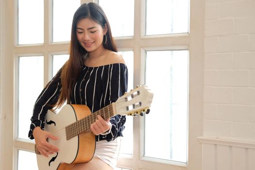 woman playing guitar at home.  leisure lifestyle concept