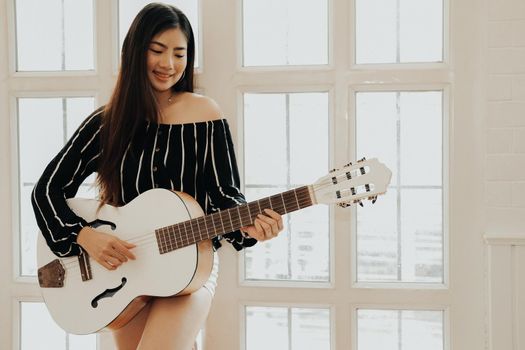 woman playing guitar at home.  leisure lifestyle concept