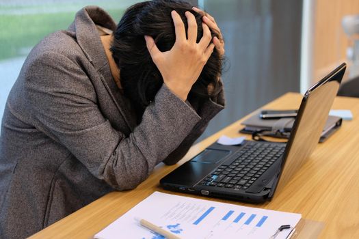 woman put hand on head feeling tired, frustrated & stressed from hard work at office. exhausted businesswoman have headache at workplace.