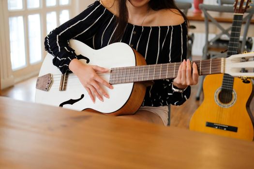 woman playing guitar at home.  leisure lifestyle concept