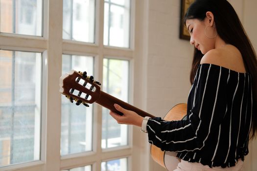 woman playing guitar at home.  leisure lifestyle concept