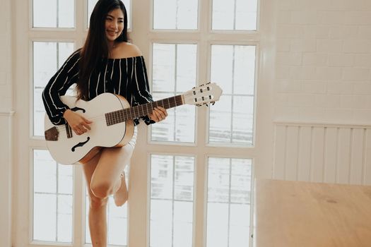 woman playing guitar at home.  leisure lifestyle concept