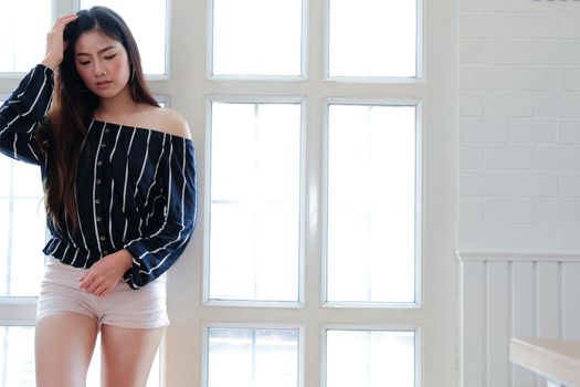 young asian woman in casual clothing posing at home