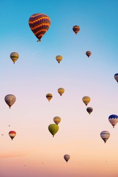 Hot air balloons flying in bright sunset sky