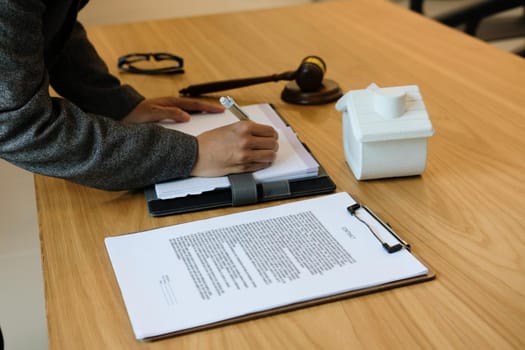 businesswoman write note with contract. woman & mortgage loan document at law firm