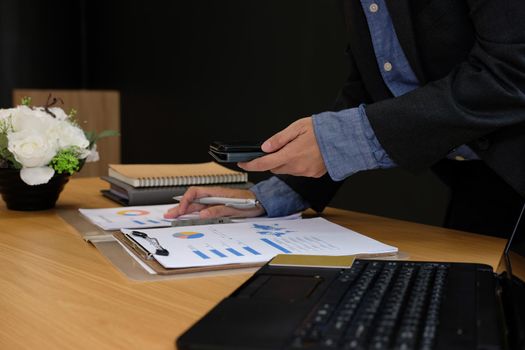 man working organizing plan with smart phone. businessman analyzing document at workplace coworking office