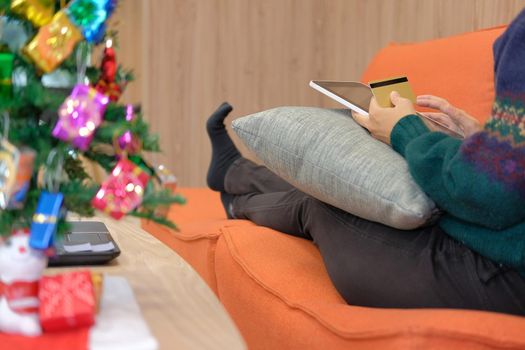 woman holding credit card & tablet for online shopping.  female buyer buying christmas gift on internet. new year holiday merry xmas celebration