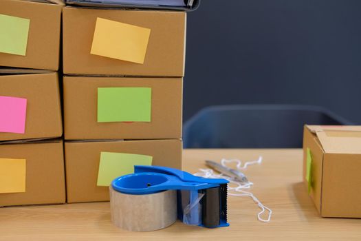 adhesive tape & parcel cardboard box at business owner workplace. Online selling, e-commerce concept