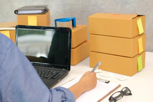 startup small business owner writing note. freelance man seller working at home.  Online selling, e-commerce concept