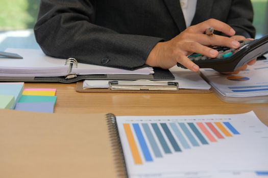 financial adviser working with calculator at office. accountant doing accounting & calculating revenue & budget. bookkeeper making calculation. finance & economy concept