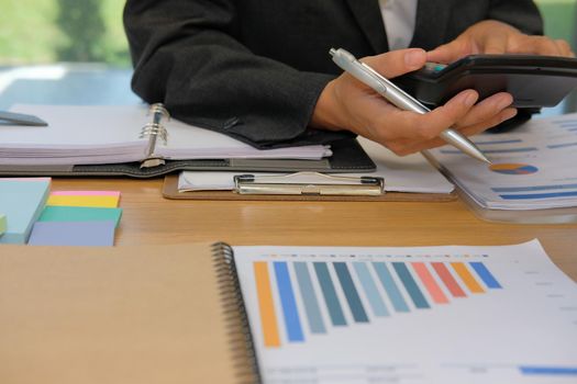 financial adviser working with calculator at office. accountant doing accounting & calculating revenue & budget. bookkeeper making calculation. finance & economy concept