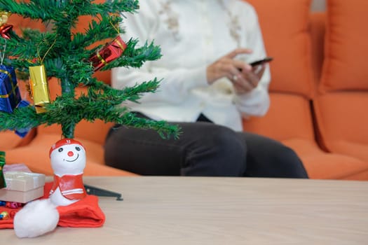 woman using smartphone at home. girl texting message on mobile phone during xmas. christmas holiday new year celebration season greetings