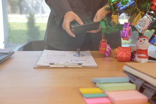 financial adviser working with calculator at office. accountant doing accounting & calculating revenue & budget. bookkeeper making calculation during christmas new year holiday