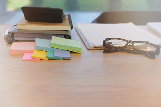 eyeglasses sticky note & notebook on office workplace desk. business workspace