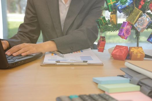 businessman using computer. startup man working with laptop with decorated christmas tree on office desk during xmas holiday