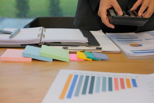 financial adviser working with calculator at office. accountant doing accounting & calculating revenue & budget. bookkeeper making calculation. finance & economy concept