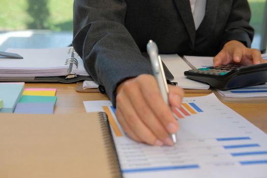 financial adviser working with calculator, business document at office. accountant doing accounting & calculating revenue & budget. bookkeeper making calculation. finance & economy concept
