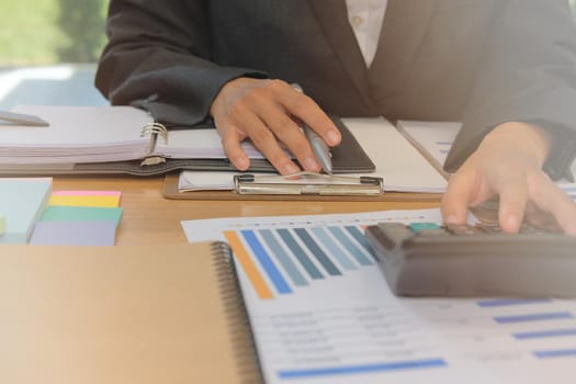 financial adviser working with calculator at office. accountant doing accounting & calculating revenue & budget. bookkeeper making calculation. finance & economy concept