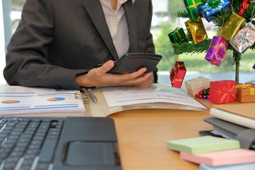 financial adviser working with calculator at office. accountant doing accounting & calculating revenue & budget. bookkeeper making calculation during christmas new year holiday