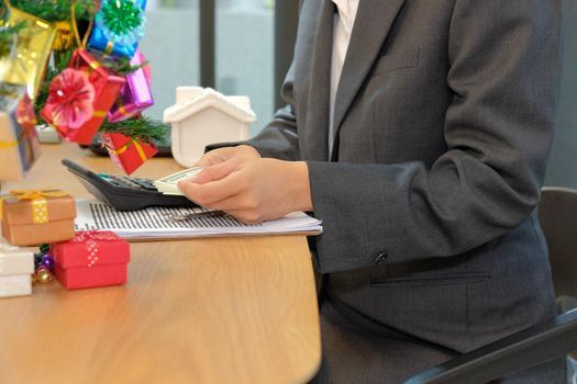 real estate agent with money cash banknote house key calculator & mortgage loan contract agreement document during christmas