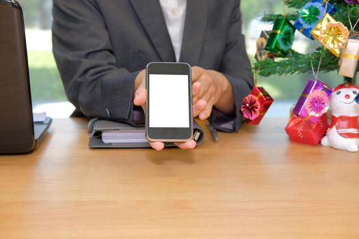 businessman showing white screen of smart phone during christmas new year holiday