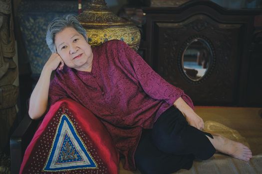 old elderly senior elder woman resting relaxing on sofa couch in living room interior