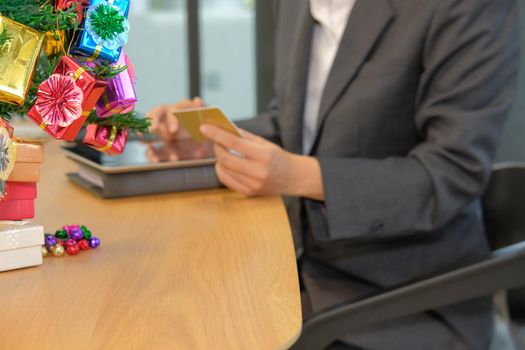 woman holding credit card using tablet for online shopping. businesswoman buying on internet, make payment on website during christmas new year holiday