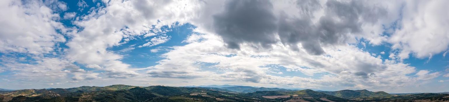 Banner view of blue sky with fluffy clouds over the land