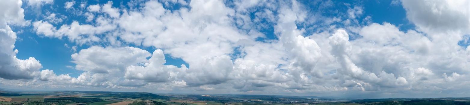 Banner view of blue sky with fluffy clouds over the land