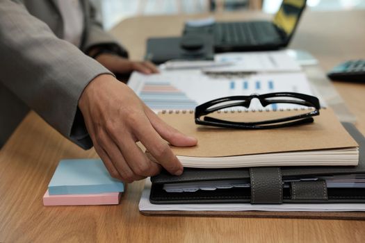 businessman picking up notebook at office. man working at workplace