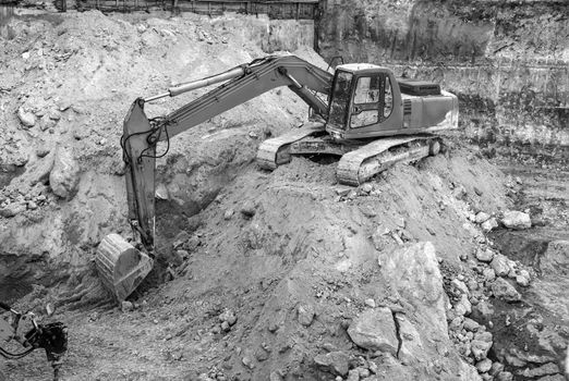 Big yellow excavator working at the construction site.