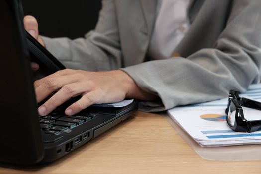 man organizing plan with smart phone. businessman working with computer at workplace coworking office