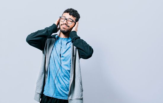 People enjoying music with headphones isolated, cheerful guy listening to music with his cell phone isolated, Person listening to music with his cell phone with headphones isolated