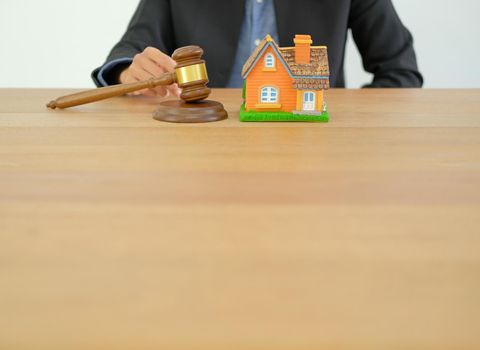 businessman lawyer with judge gavel & house model. buying selling & renting real estate property
