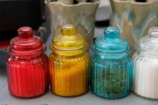 brown rock sugar in red yellow blue white glass jar pot