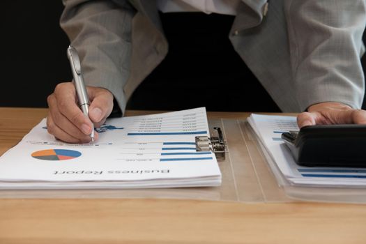 financial adviser working with calculator, business document at office. accountant doing accounting & calculating revenue & budget. bookkeeper making calculation. finance & economy concept