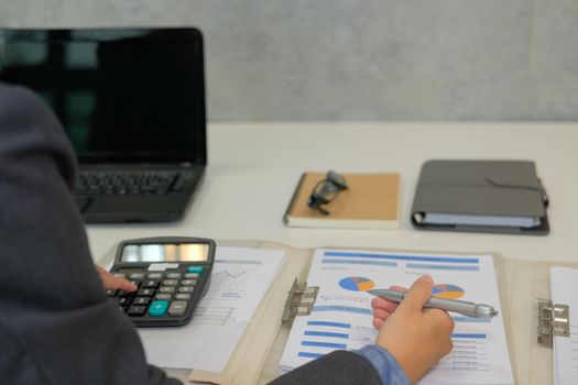 financial adviser working with calculator at office. accountant doing accounting & calculating revenue & budget. bookkeeper making calculation. finance & economy concept