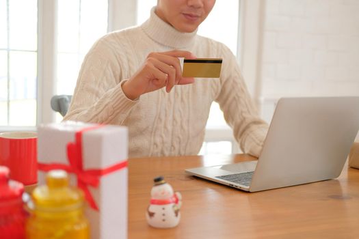 man holding credit card for online shopping. male buyer buying christmas gift on internet. new year holiday merry xmas celebration