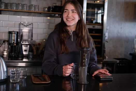 pretty brunette girl making aeropress coffee in modern coffee shop.