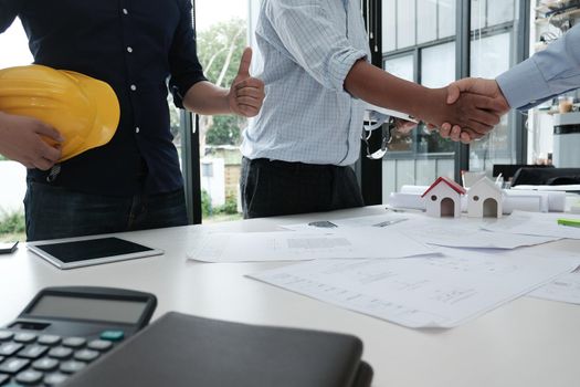 architect & customer shaking hands at workplace. Engineer handshaking with partner for successful deal in building project development. business teamwork concept