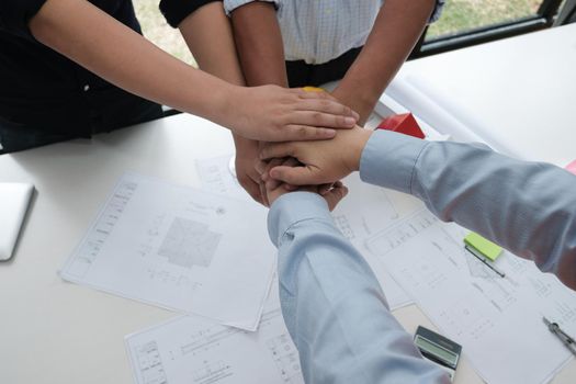 architect & customer joining hands at workplace. Engineer put hand together with partner for successful deal in building project development. business teamwork concept