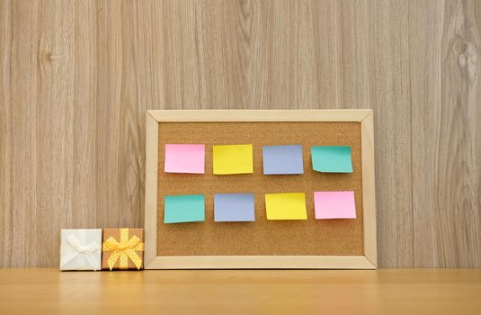sticky notes reminder on cork board & gift box. bulletin corkboard