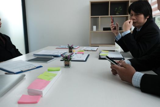 businessman using smartphone in meeting room. man holding mobile phone at office