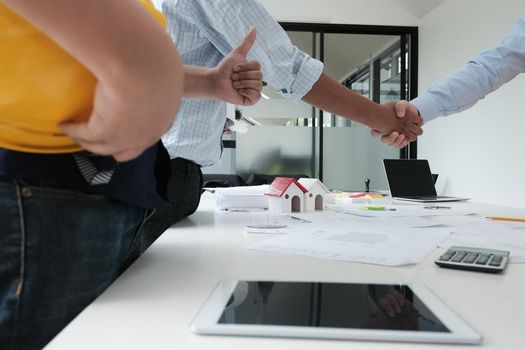 architect & customer shaking hands at workplace. Engineer handshaking with partner for successful deal in building project development. business teamwork concept
