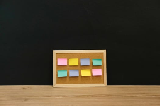 sticky notes paper reminder on cork board on wooden desk. bulletin corkboard