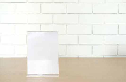 white label in cafe. display stand for acrylic tent card near white brick wall. mockup menu frame on table in restaurant. space for text