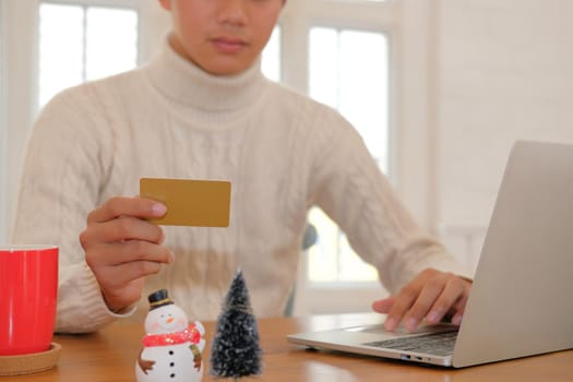 man holding credit card for online shopping. male buyer buying christmas gift on internet. new year holiday merry xmas celebration